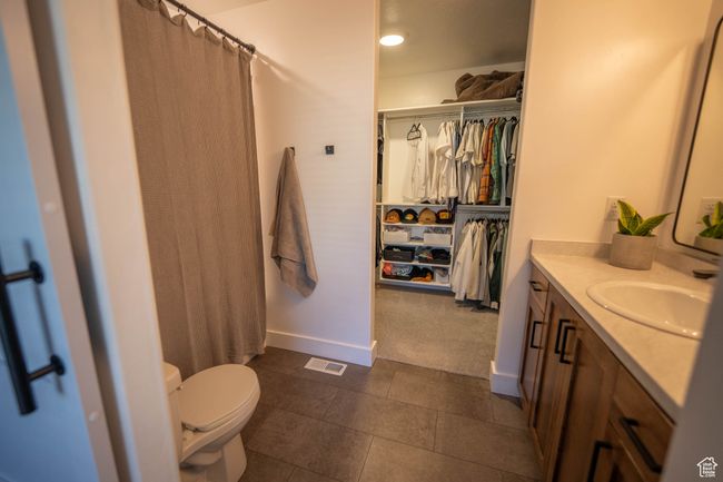 This stylish Primary Bath features a rustic maple vanity in a rich walnut stain, a gorgeous custom-framed mirror, and updated light and plumbing fixtures. Plus—a spacious walk-in closet with plenty of hanging space and built-in shelving to keep everythi | Image 17