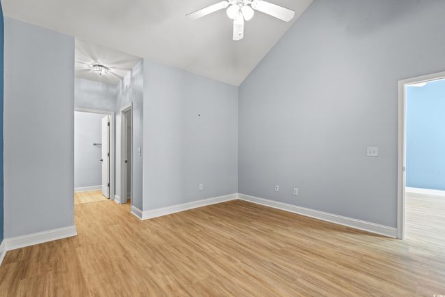 Empty room featuring ceiling fan, vaulted ceiling, light wood-style floors, and baseboards | Image 15
