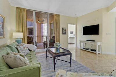 Living room with ceiling fan and ornamental molding | Image 2