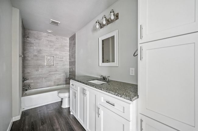 Bathroom featuring shower / bathtub combination, vanity, and dark wood-type flooring | Image 14