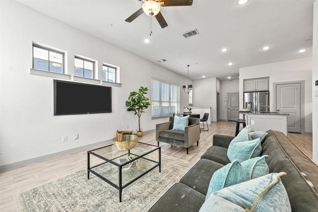 Living room with ceiling fan and light wood-type flooring | Image 12