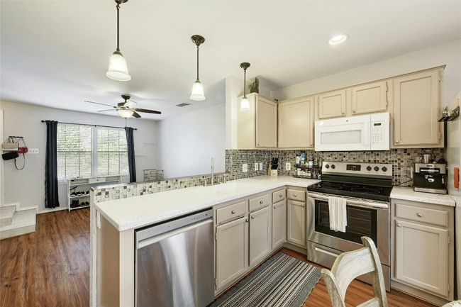 The kitchen boasts updated appliances and ample cabinet space, ideal for preparing meals | Image 8