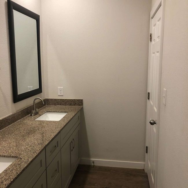 Bathroom with double vanity, wood finished floors, and baseboards | Image 19