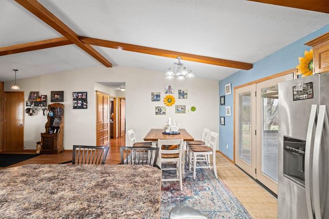 Dining area featuring lofted ceiling with beams, baseboards, and a notable chandelier | Image 21