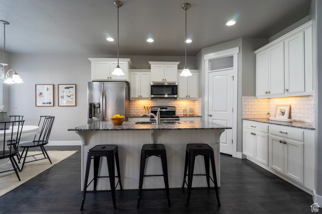 Kitchen with appliances with stainless steel finishes, a sink, baseboards, a breakfast bar area, and recessed lighting | Image 4
