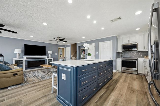 This open-concept kitchen seamlessly connects to the living area, perfect for entertaining. | Image 7