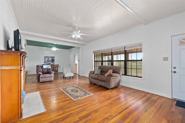 Living room with a ceiling fan and wood finished floors | Image 10