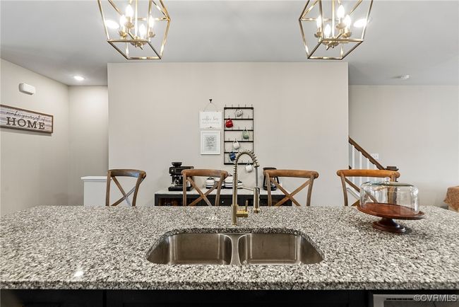 Kitchen with pendant lighting, an inviting chandelier, light stone counters, and sink | Image 38