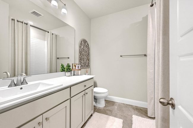 Full bathroom with double vanity, toilet, a sink, visible vents, and baseboards | Image 30