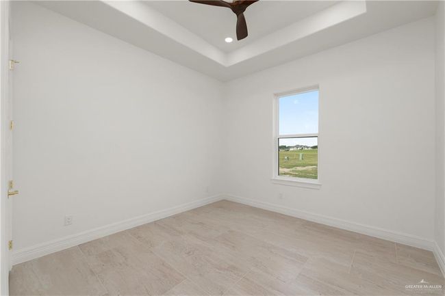 Expansive windows provide natural light and scenic views of the sprawling half-acre lot—perfect for enjoying the peaceful surroundings from the comfort of your own room. | Image 23