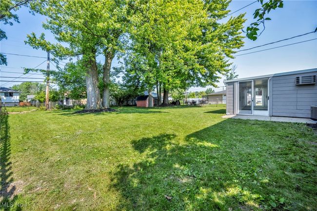 Fenced backyard with a shed and a wall unit AC | Image 44