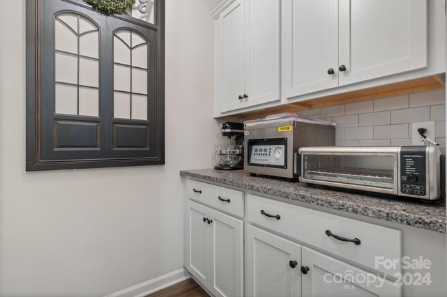 Butler's pantry has multiple cabinets. Granite counter top. | Image 17