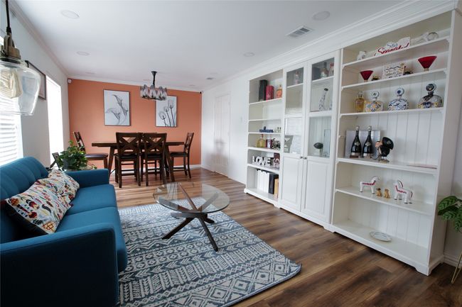 Living area featuring ornamental molding, a chandelier, and dark wood-type flooring | Image 4