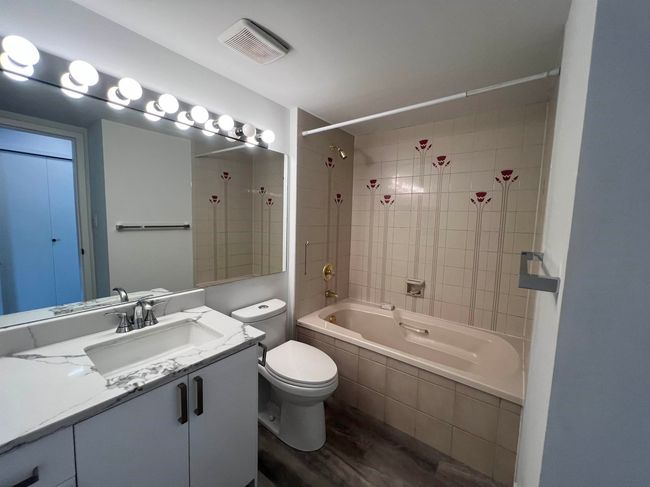 Bathroom featuring tiled shower / bath combo, vanity, and wood finished floors | Image 27