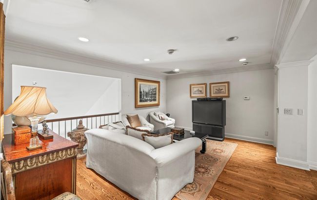 Living area with ornamental molding, light wood-style flooring, recessed lighting, and baseboards | Image 28