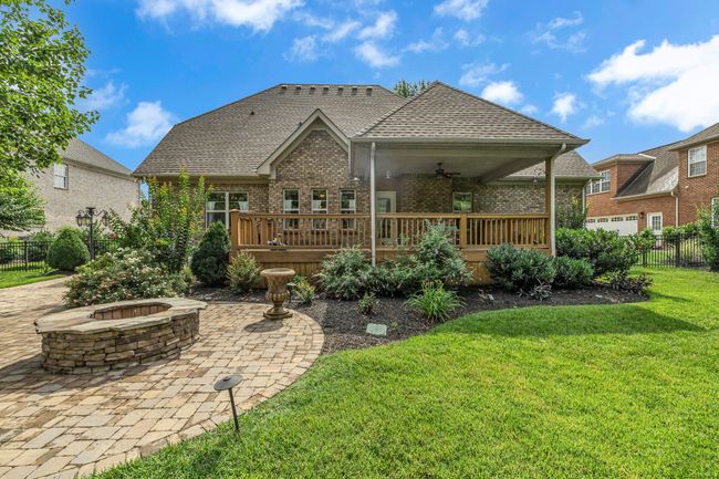 The back offers professional landscaping, a fire pit, a patio, a covered deck, and lush grass. Yes, these could be your favorite places this summer and fall! | Image 43
