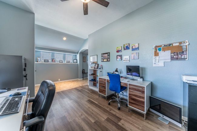 Office with arched walkways, a ceiling fan, dark wood-type flooring, lofted ceiling, and baseboards | Image 28