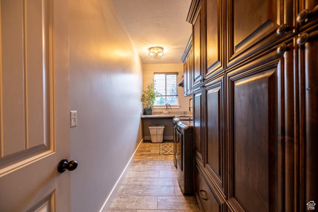 Kitchen featuring a textured ceiling, wood finished floors, and light countertops | Image 36