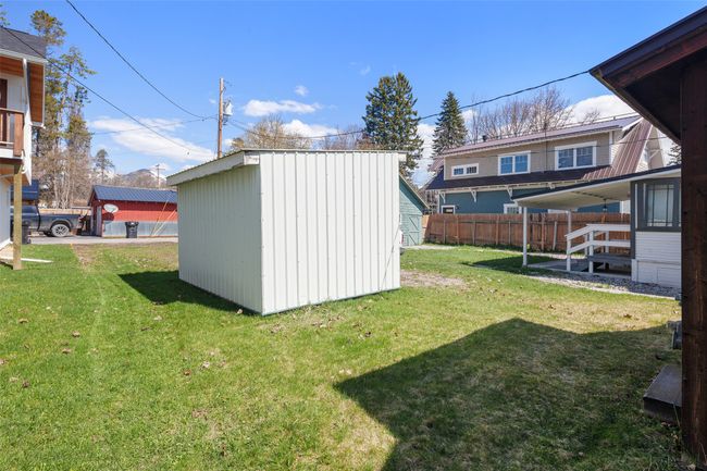 View of yard with fence, a storage shed, and an outbuilding | Image 26