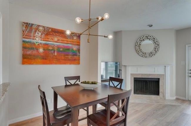 Dining room featuring light wood finished floors, a fireplace, and a chandelier | Image 7