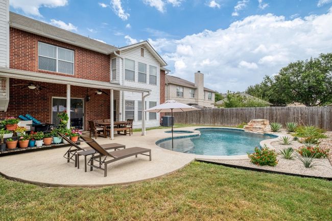 View of swimming pool with a ceiling fan, a fenced backyard, a patio, and a pool with connected hot tub | Image 33