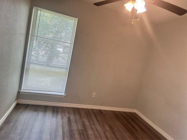 Spare room featuring dark wood-style floors, baseboards, and ceiling fan | Image 9