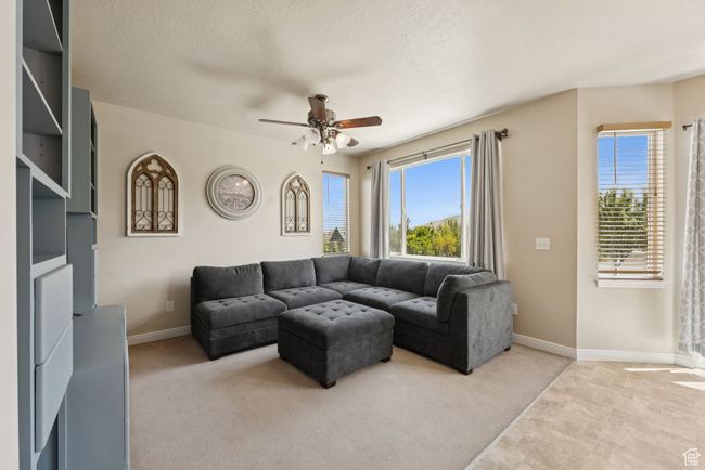 Living room featuring a ceiling fan and light colored carpet | Image 9