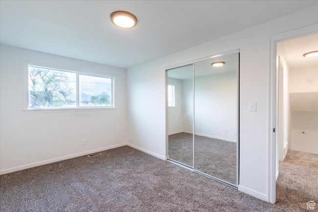 Unfurnished bedroom with visible vents, carpet, baseboards, and a closet | Image 23