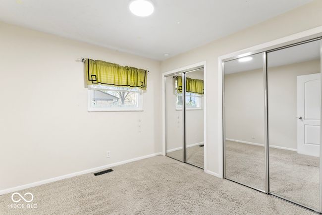 unfurnished bedroom with visible vents, baseboards, two closets, and carpet floors | Image 19