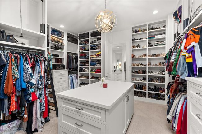 Expansive custom closet with built-ins, center island, plenty of lighting & upper storage solutions. | Image 38