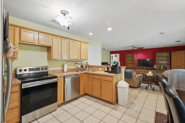 Kitchen with ceiling fan, a peninsula, appliances with stainless steel finishes, a sink, and open floor plan | Image 16
