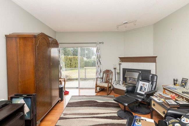 Interior space with light wood-type flooring and a tile fireplace | Image 12