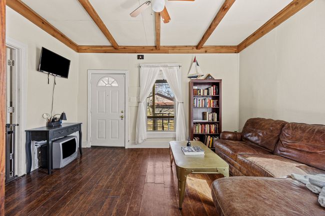 Living room featuring hardwood / wood-style flooring, a ceiling fan, and beamed ceiling | Image 6