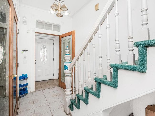Entryway with light tile patterned floors, stairs, and an inviting chandelier | Image 8