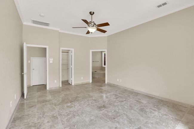 Unfurnished bedroom with baseboards, visible vents, a spacious closet, and crown molding | Image 36