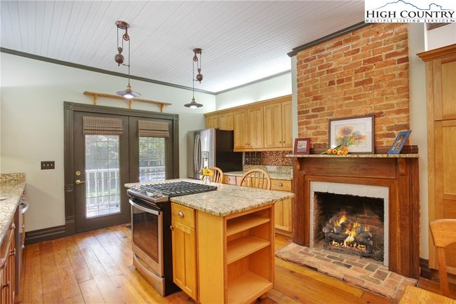 Original fireplace with newer gas logs in the kitchen. Gas range. | Image 12