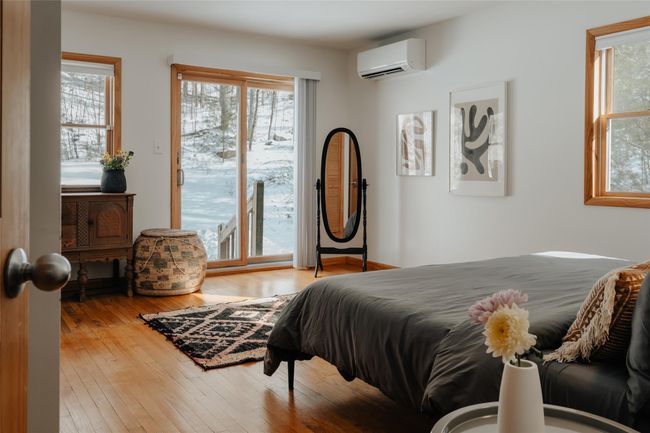 Bedroom featuring an AC wall unit, access to outside, and light hardwood / wood-style flooring | Image 11