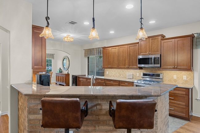 The kitchen has a large breakfast bar, perfect for quick or informal dining. | Image 13