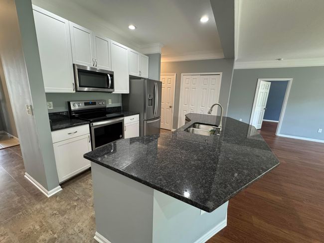 Open kitchen with granite countertop, under mount sink and newer SS appliances | Image 10