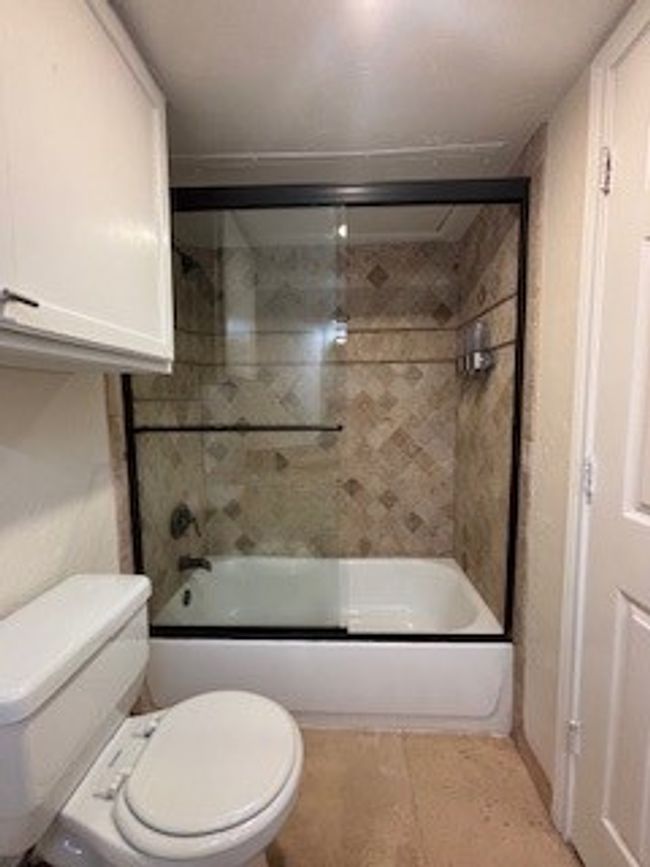 Full bath with toilet and enclosed tub / shower combo and medicine cabinet. | Image 13