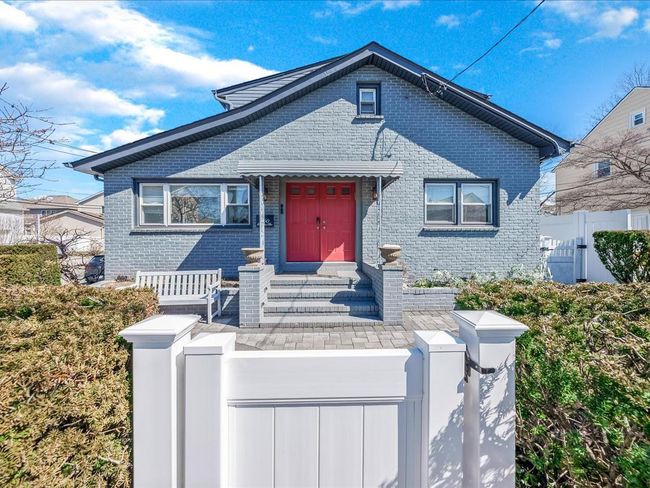 View of front of home featuring brick siding, a fenced front yard, a gate, and entry steps | Image 37
