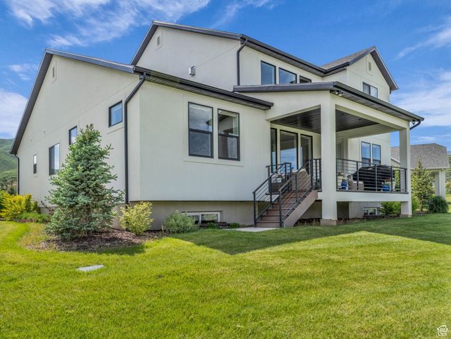 View of front of home with a front lawn, stucco siding, and a porch | Image 47