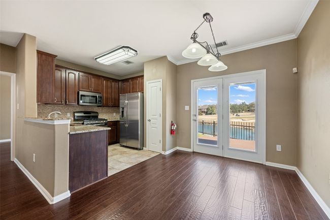 Kitchen with light granite counters, stainless steel appliances, tile floors, and tasteful backsplash | Image 5
