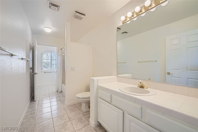 Bathroom with shower / bathtub combination, visible vents, toilet, vanity, and tile patterned flooring | Image 47