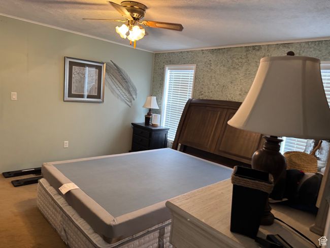 Bedroom with ornamental molding, ceiling fan, wallpapered walls, and carpet floors | Image 13