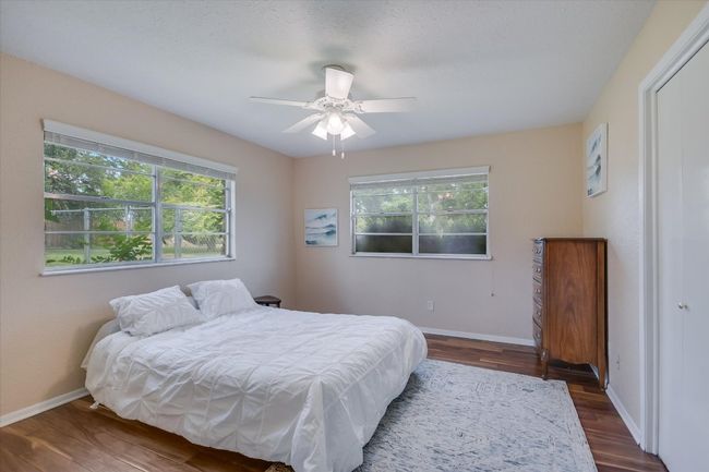 The master bedroom has acacia hardwood flooring and is sunny & bright with windows everywhere. | Image 23