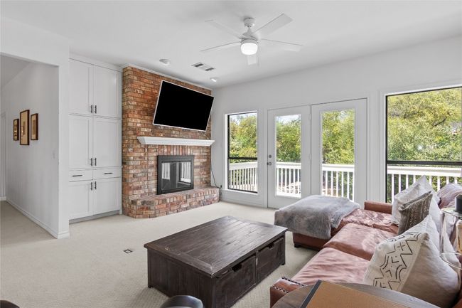 Living area with a ceiling fan, light carpet, a healthy amount of sunlight, and visible vents | Image 33