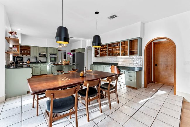 Dining area featuring light tile patterned floors and arched walkways | Image 9