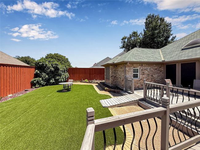 Fenced backyard with a wooden deck | Image 38