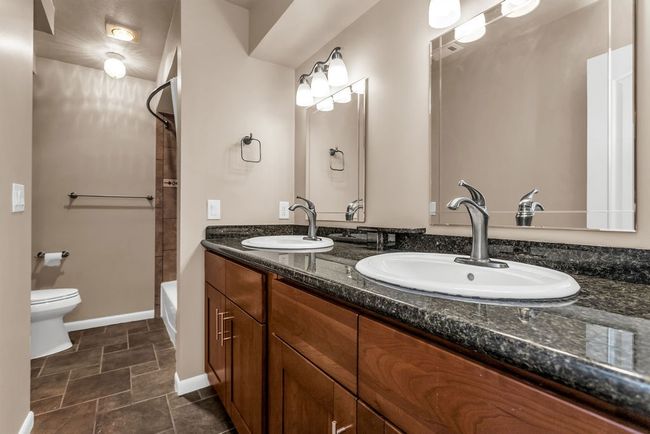 Full bath featuring double vanity, shower / tub combination, and stone finish floors | Image 22